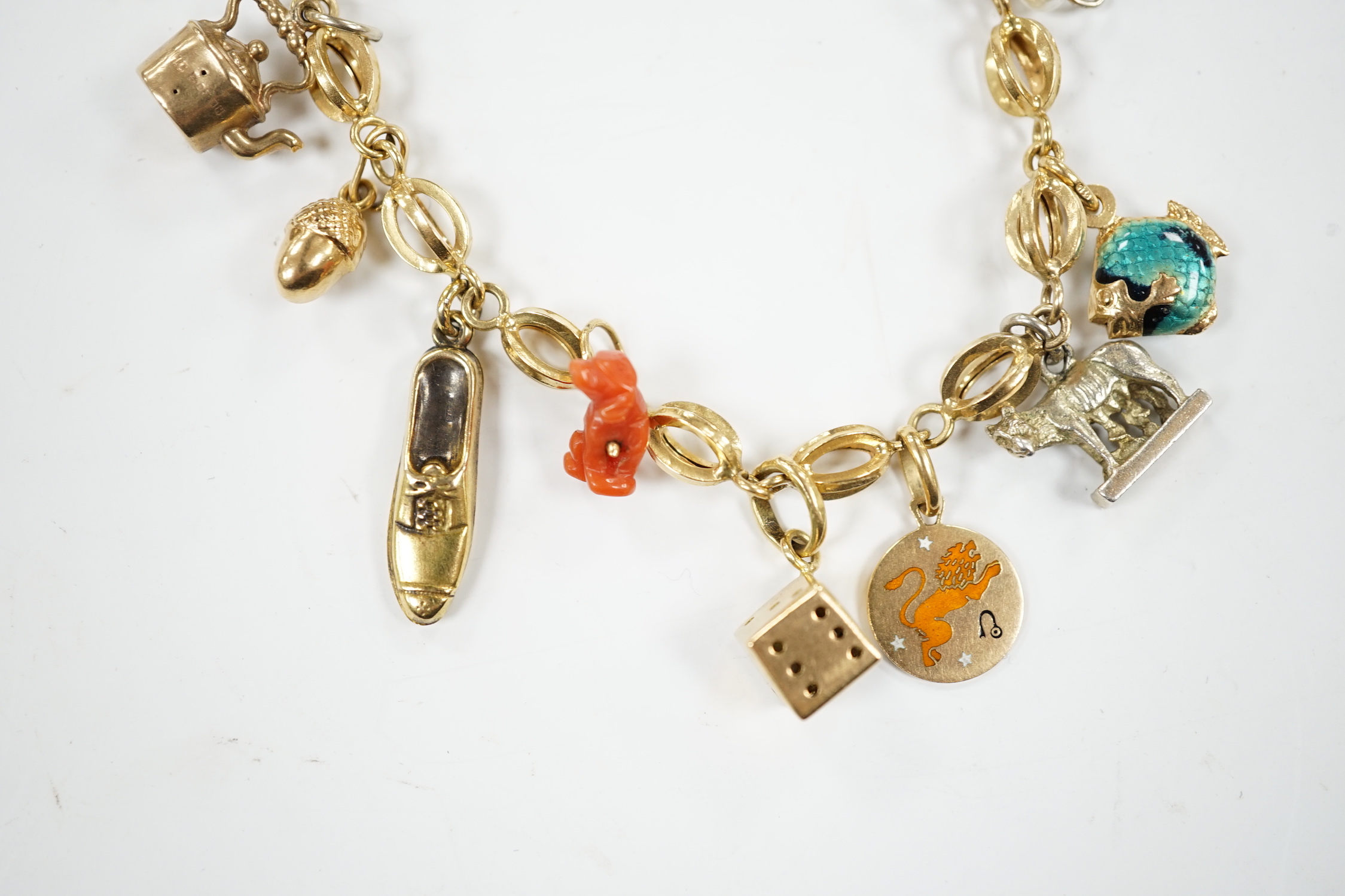 An Italian 750 charm bracelet, hung with eleven assorted charms including 9ct, yellow metal and 800 standard white metal